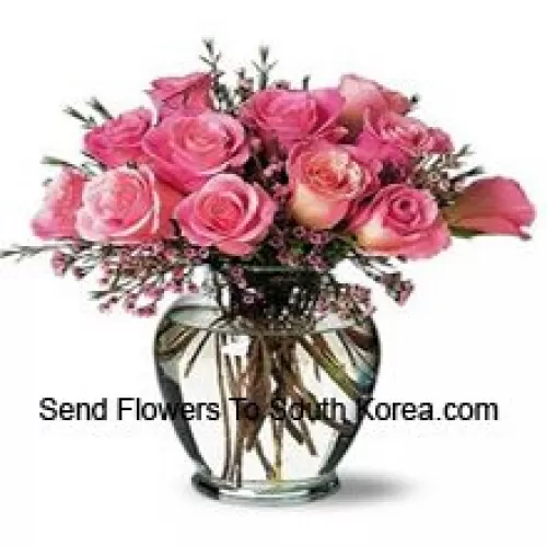 12 roses roses avec quelques fougères dans un vase