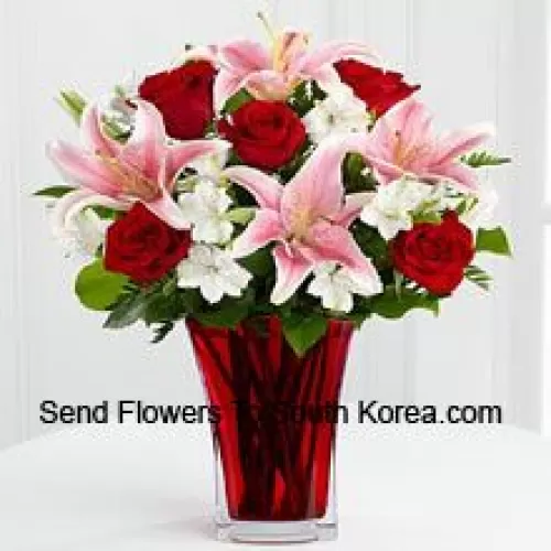6 roses rouges et 5 lys roses avec des remplissages saisonniers dans un beau vase en verre