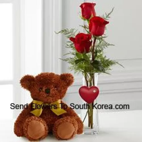 Trois roses rouges dans un vase en tube à essai rouge et un mignon ourson brun de 10 pouces (Nous nous réservons le droit de substituer le vase en cas de non disponibilité. Stock limité)